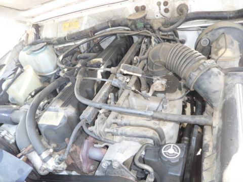 1994 Jeep Cherokee - Close-up view of the engine bay, highlighting various hoses, wiring, and engine parts within a Jeep Cherokee.