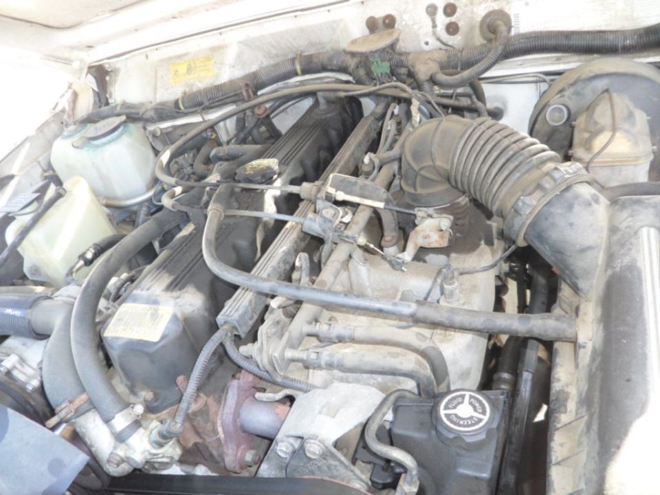 Engine bay of a Jeep Cherokee, showing hoses and engine components