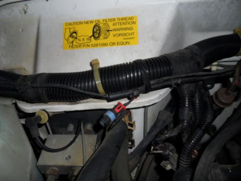 1994 Jeep Cherokee - Close-up of engine bay components with a warning sticker for oil filter installation.