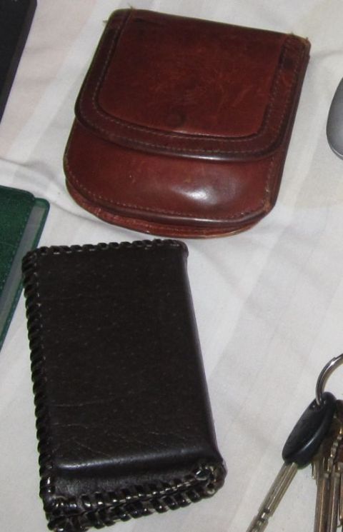 1990 Ford Bronco - Leather coin purse and wallet with keys on a white striped surface.
