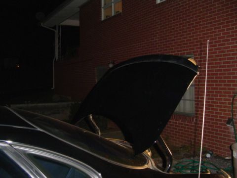 1999 Ford Taurus - The trunk of a car is open, revealing its interior structure against a brick building.