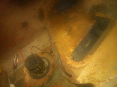 1979 Ford Bronco - This image shows a close-up view of the interior floor of a vehicle, with visible rust and various components.