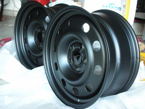2004 Ford Crown Victoria - A pair of matte black steel wheels are displayed, possibly for an upgrade or replacement.