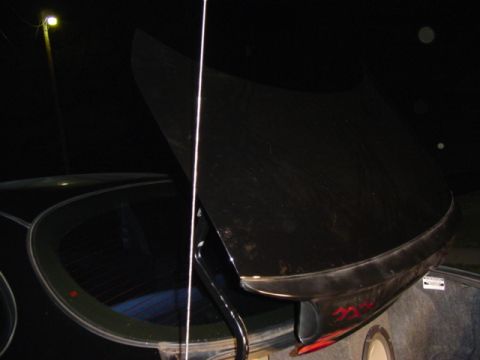 1999 Ford Taurus - Night shot of a black sedan with the trunk lid raised under a parking lot light, showing the mast antenna, red flame graphics on the tailli…