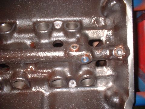 1969 Ford Mustang - This image shows a close-up view of an engine component, likely a cylinder head, with visible oil residue and bolt holes.