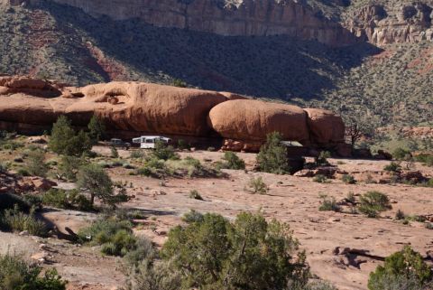 1995 Ford Bronco - Two vehicles are parked in a desert landscape with large rock formations and sparse vegetation.