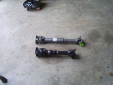 1992 Ford Bronco - Two driveshafts are laid out on a concrete surface, one appears to be a replacement part.
