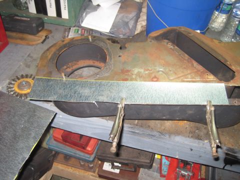 1979 Ford Bronco - A close-up view of a rusty metal part being worked on in a garage setting.
