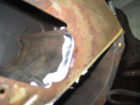 1979 Ford Bronco - This image shows a close-up of a rusted metal panel with a fresh weld, possibly part of a vehicle repair.