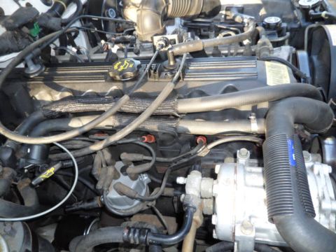 1994 Jeep Cherokee - Close-up view of an engine bay, showing various hoses, wiring, and engine components.