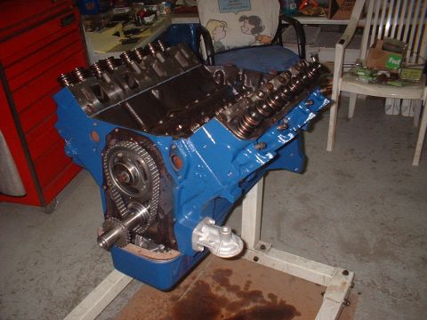 1969 Ford Mustang - A blue V8 engine, possibly a Ford, is mounted on an engine stand in a garage setting.