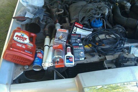 2000 Mercury Grand Marquis - Various automotive parts, including oil and filters, are displayed on top of an open engine bay.