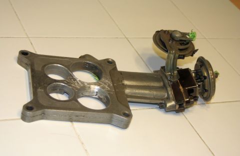 1976 Ford Ranchero - A carburetor part is shown on a tiled surface, with a Supermotors.net watermark visible.
