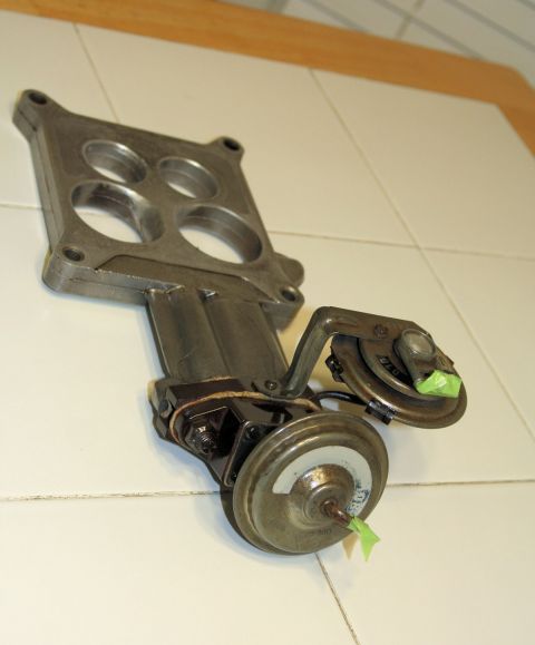 1976 Ford Ranchero - A close-up view of a carburetor part, likely from an older vehicle, showing its mechanical components.