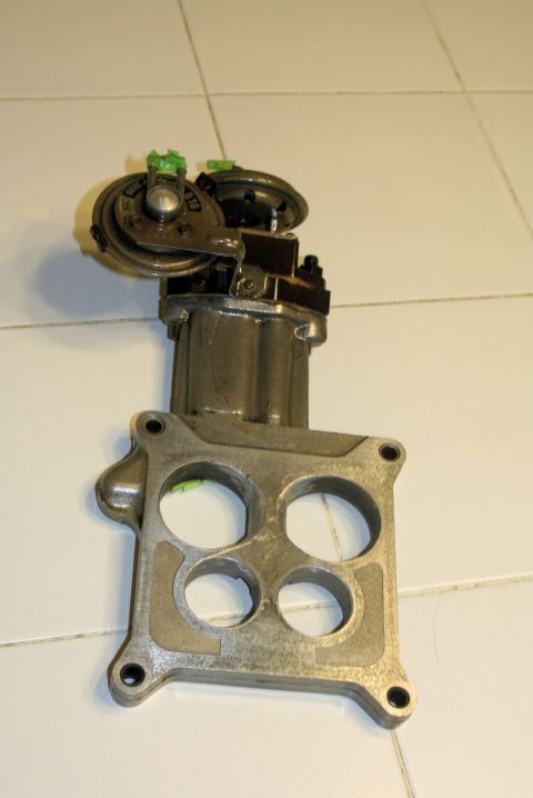 1976 Ford Ranchero - A carburetor assembly, likely for an older vehicle, is shown against a tiled background.