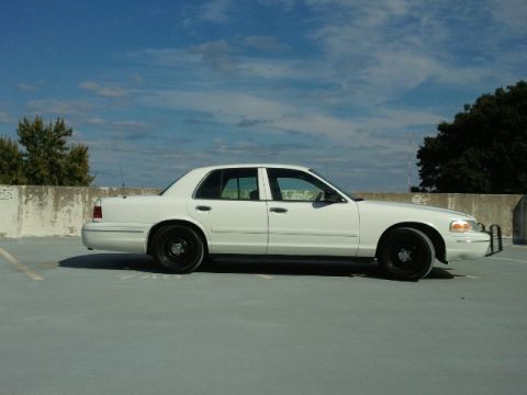 1998 Ford Crown Victoria - Side view of a white 1998 Ford Crown Victoria sedan with black wheels.