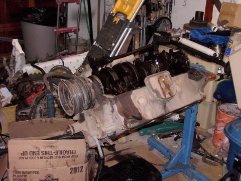 1980 Ford Bronco - Engine block on stand, surrounded by garage clutter. Box shows '2012'.