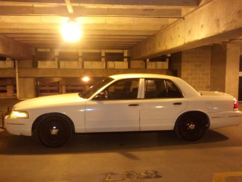 1998 Ford Crown Victoria - A white 1998 Ford Crown Victoria is parked in a garage, viewed from the side.