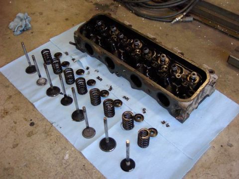1980 Ford Bronco - Disassembled engine cylinder head components are organized on a shop towel, ready for cleaning or reassembly.