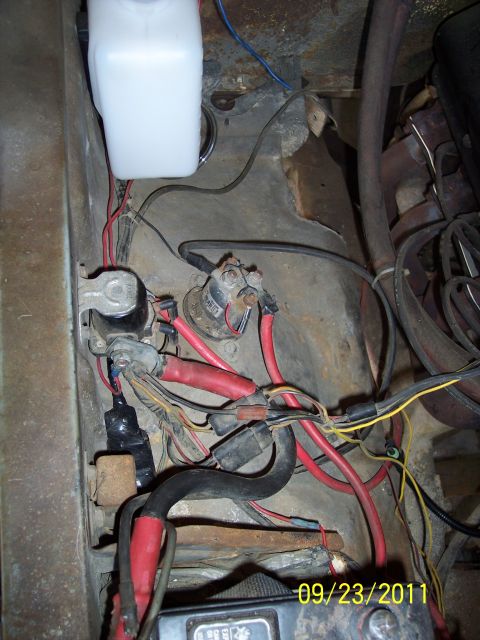 1973 Ford F-250 - The image shows a tangle of wires and electrical components under the hood of a vehicle, including battery terminals and a starter solenoid.