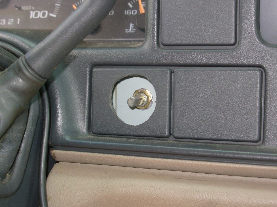 Toggle switch installed in a gray dash blank-out panel