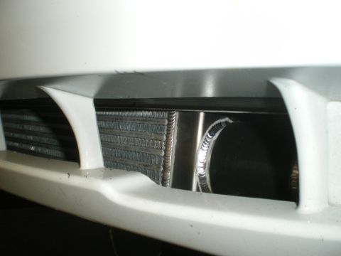2004 Ford Crown Victoria - Close-up view of a vehicle's intercooler and radiator, partially visible behind white bumper trim.