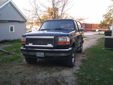 1994 Ford Bronco - This 1994 Ford Bronco is parked in a driveway with a house and trees in the background.