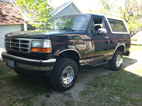 1994 Ford Bronco - This Ford Bronco is parked outside a house on a sunny day.