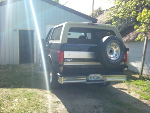 1994 Ford Bronco - This Ford Bronco, likely from the early 1990s, is parked outside a residential garage.