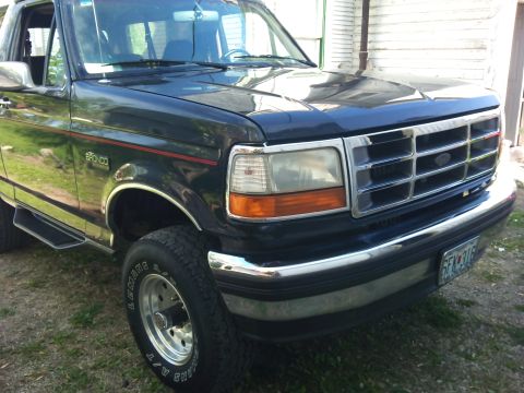 1994 Ford Bronco - This 1994 Ford Bronco features a prominent chrome grille and bumper, seen from a 3/4 front angle.