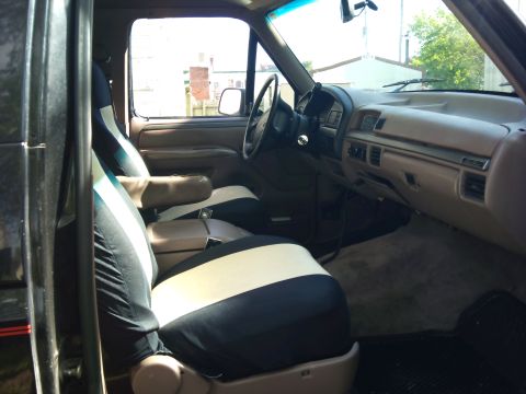 1994 Ford Bronco - The interior of a 1994 Ford Bronco features two-tone seat covers and a tan dashboard.