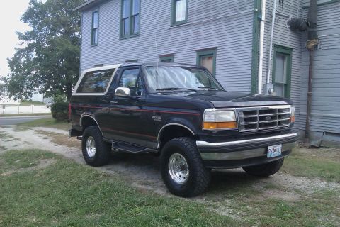 1994 Ford Bronco - This 1994 Ford Bronco is seen from a 3/4 front angle, parked on a gravel driveway next to a house.