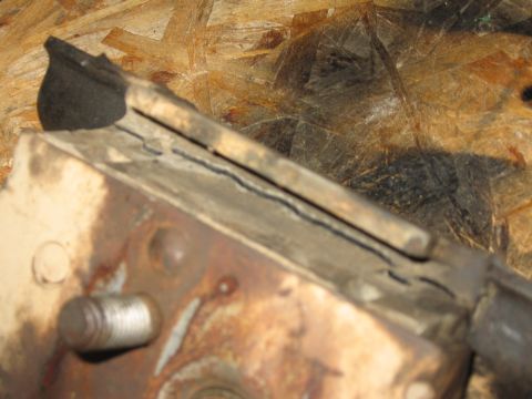 1995 Ford Bronco - A close-up view of a worn motor mount part, showing damage to the rubber and metal components.