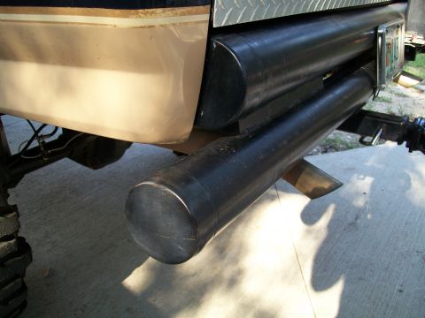 1990 Ford Bronco - Vehicle rear bumper with custom dual exhaust pipes and tow hitch visible.