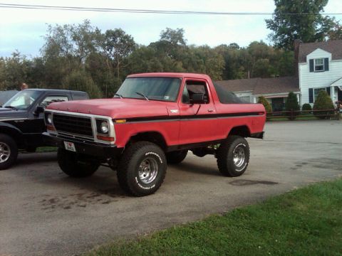 1979 Ford Bronco - This lifted red Bronco features a soft top and aggressive off-road tires, suggesting it's ready for adventure.