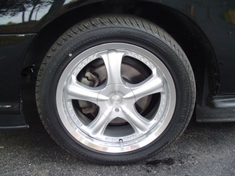 1999 Ford Taurus - A close-up view of a car's aftermarket wheel and tire, showing the brake rotor behind the spokes.