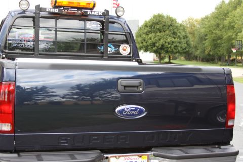 2006 Ford F-350 - Rear view of a dark blue Ford Super Duty pickup truck with a rack and light bar.