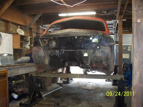 1990 Ford Bronco - Car body undergoing repairs in a workshop, front end removed.
