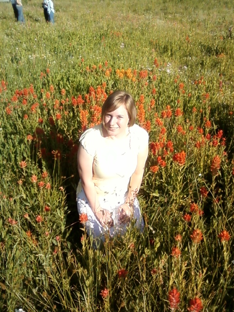1979 Ford Bronco - A woman poses in a field of wildflowers, with two people visible in the background.