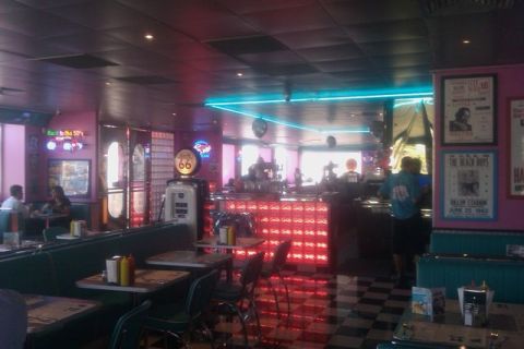 1991 Ford LTD Crown Victoria - Interior of a retro-themed diner a vintage gas pump and neon lighting.