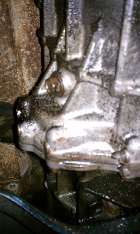 1990 Ford Bronco - Transmission housing appears to be leaking fluid; close-up view of the component.
