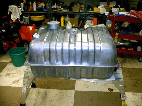 1990 Ford Bronco - A large aluminum fuel tank is shown on a stand in a garage setting.