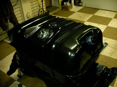 1990 Ford Bronco - A freshly painted black fuel tank is shown in a garage setting with a checkered floor.