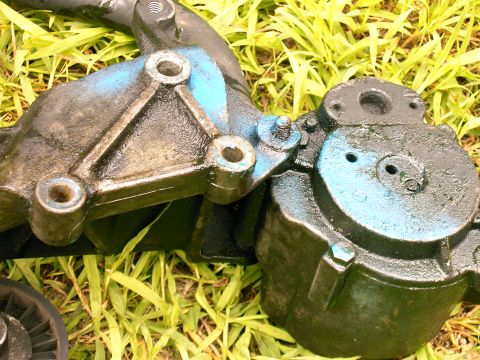 1990 Ford Bronco - A smog pump assembly, likely from an older vehicle, is shown against a backdrop of grass.