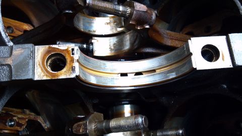 1990 Ford Bronco - Close-up view of worn engine crankshaft bearings, indicating potential mechanical issues.