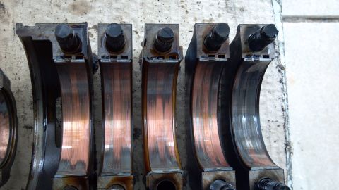 1990 Ford Bronco - Close-up of engine crankshaft bearings, showing signs of wear and potential damage.