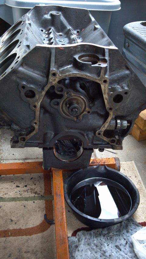 1990 Ford Bronco - Engine block on a stand, ready for work, with an oil drain pan underneath.