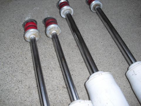 1986 Ford Bronco - A set of four shock absorbers, likely for an off-road vehicle, are displayed on a concrete floor.