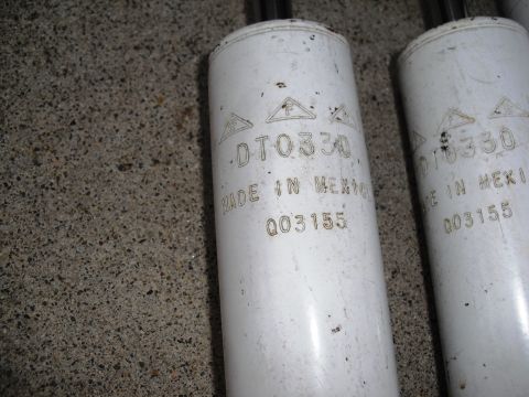 1986 Ford Bronco - Close-up of two shock absorbers, each marked with part number DT0330 and "MADE IN MEXICO".