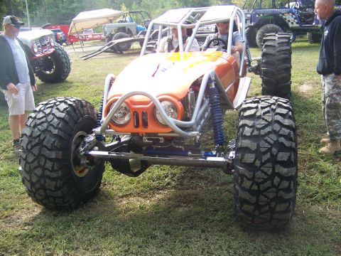2001 Dodge 1500 - A custom-built buggy with massive off-road tires and a prominent roll cage is displayed outdoors.